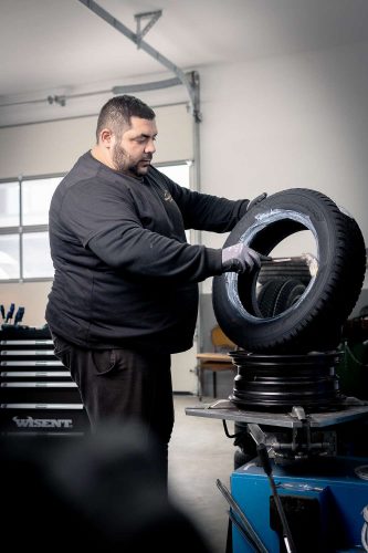 Mechaniker bereitet einen Reifen für einen Reifenwechsel vor.